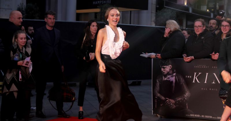 Lily-Rose Depp suffers wardrobe malfunction as her plunging top catches gust of wind during 'The King' premiere