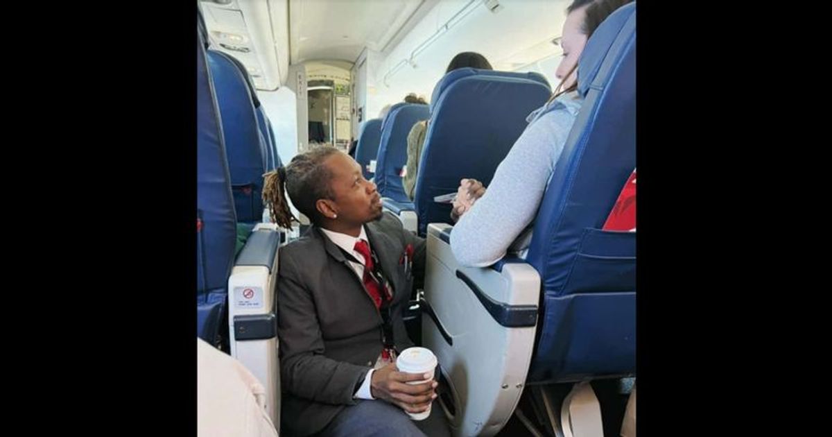 Heartwarming viral photo shows Delta flight attendant holding nervous passenger's hand as he comforts her